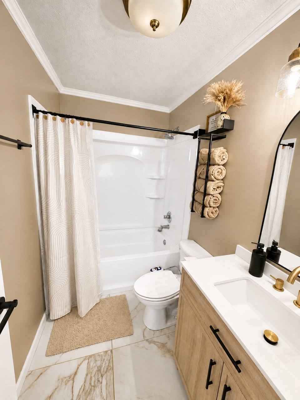 Bathroom with bathtub and shower, toilet, wooden vanity, mirror and towel rack