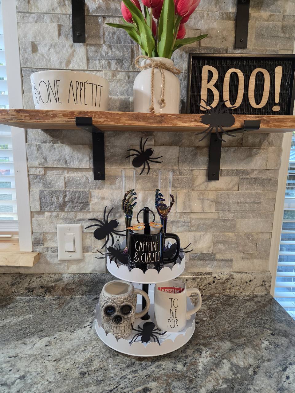 Seasonal Halloween mugs, decorative spiders and a BOO sign at the kitchen coffee bar