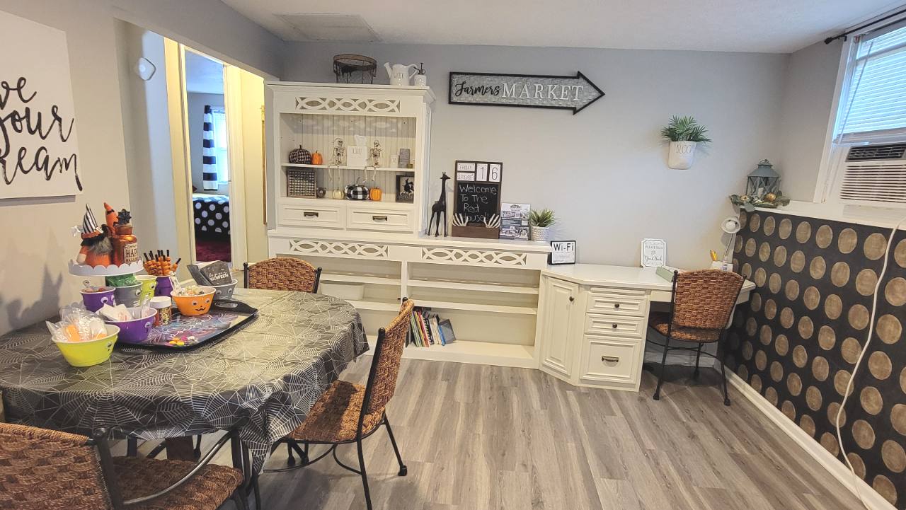 Dining area with round table, shelving and a desk, decorated for Halloween