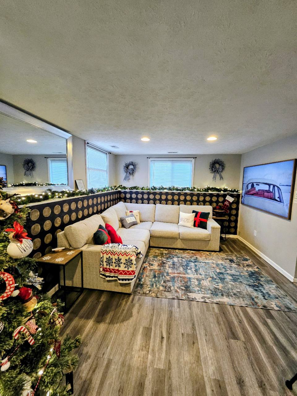 Living room with sectional sofa, television, Christmas tree and lighted garland